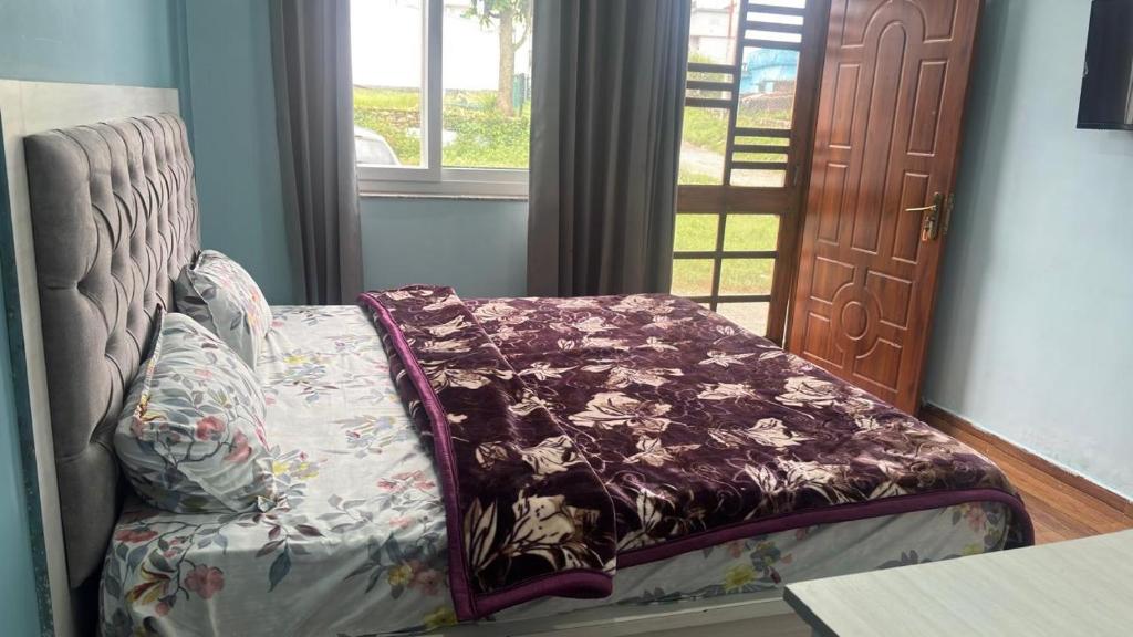 a couch with a blanket on it in front of a door at Bhadraj Valley Homestay in Dehradun