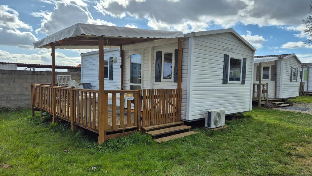 a tiny house with a porch and a gazebo at MOBILE-HOME AC CLIM prox Europapark et Rulantica in Boofzheim