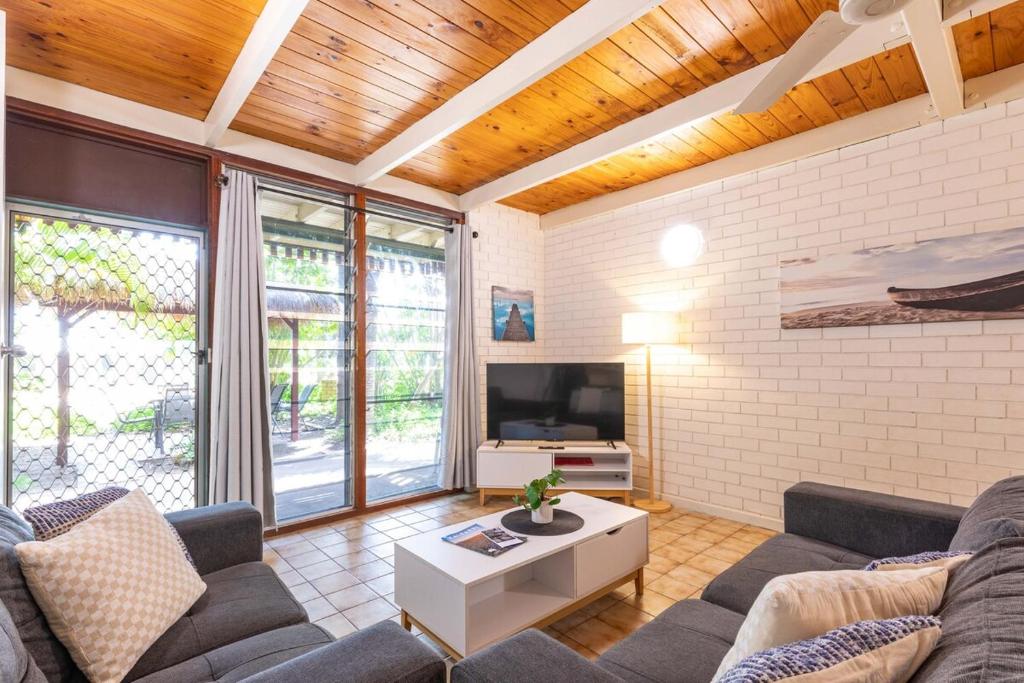 a living room with a couch and a tv at Reef Villa- Kalbarri Central with Pool in Kalbarri