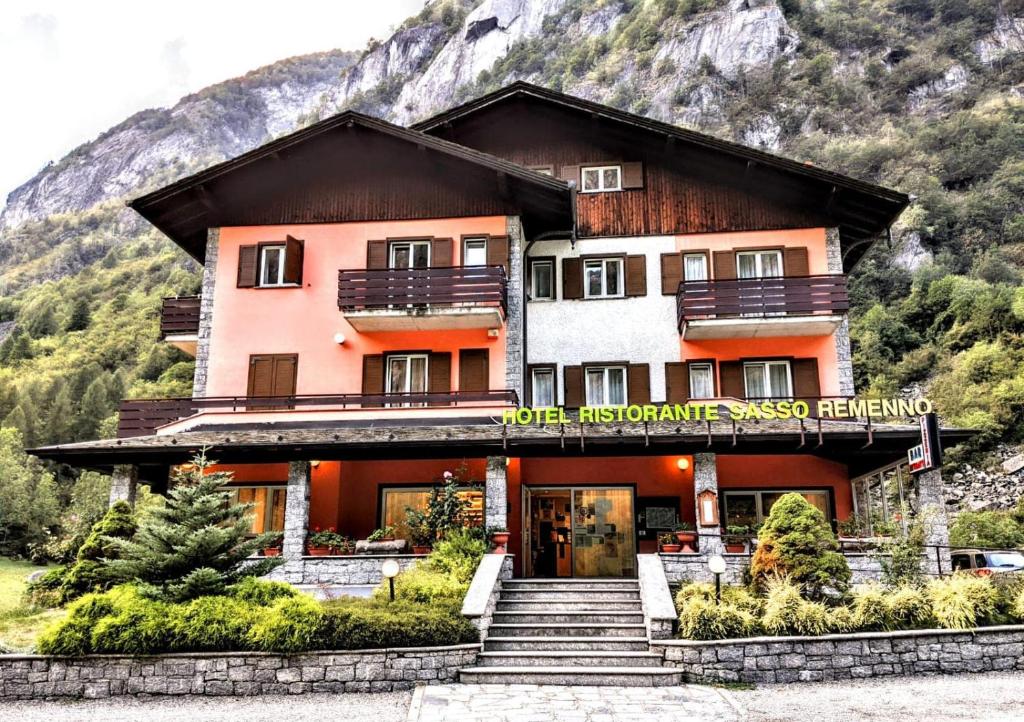 a building with stairs in front of a mountain at Hotel Ristorante Sasso Remenno in Val Masino