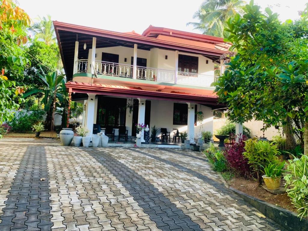 a house with a cobblestone driveway in front of it at Ahungalla Ocean Villa in Ahungalla