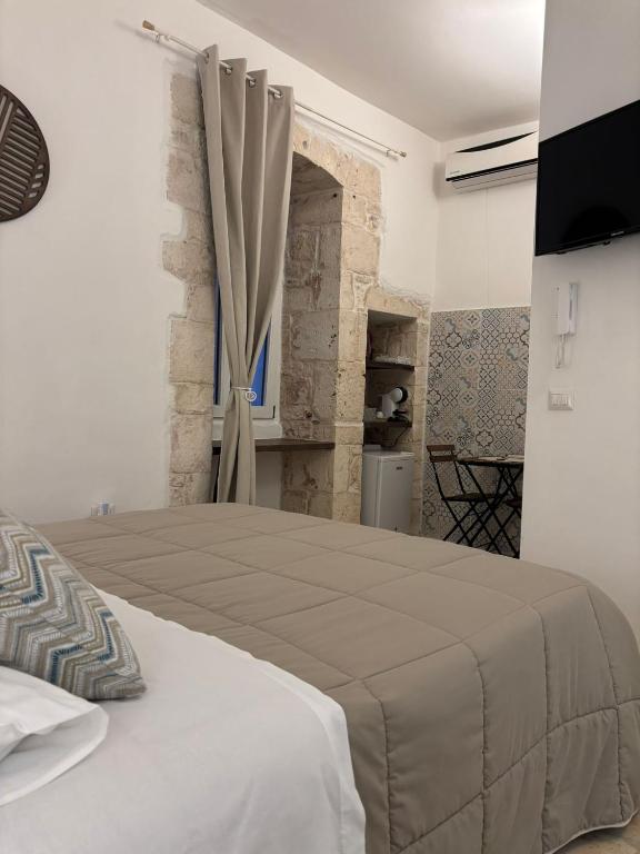 a bedroom with a large bed with a window at Dioniso Affittacamere in Conversano