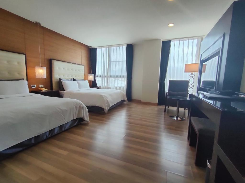 a hotel room with two beds and a flat screen tv at Hotel Modern Puli in Puli