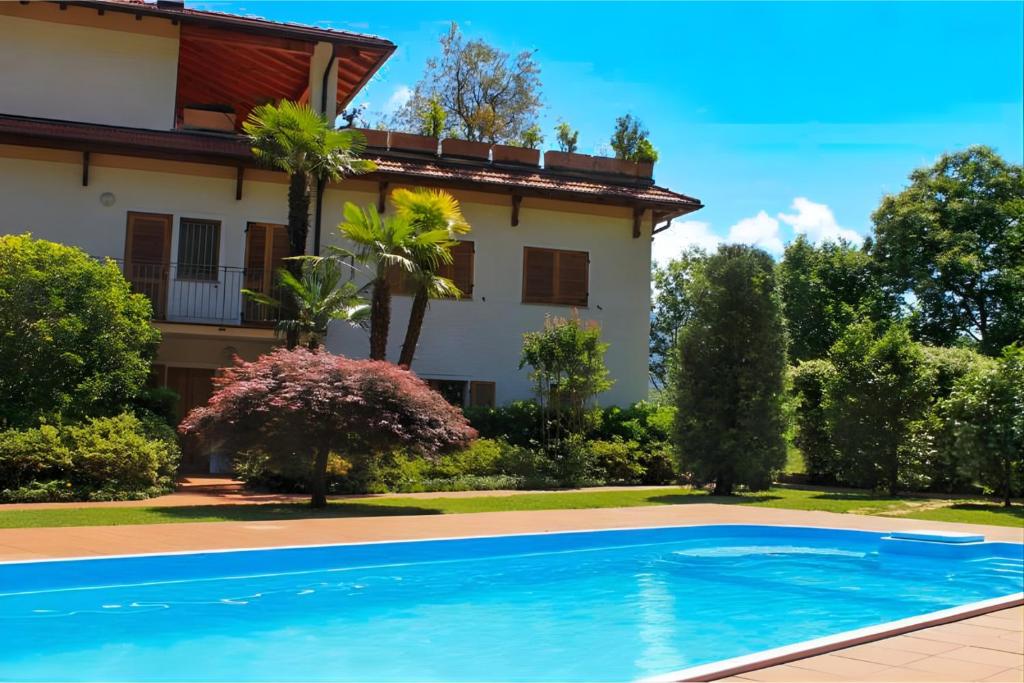 a villa with a swimming pool in front of a house at Eden Rock in Cannobio