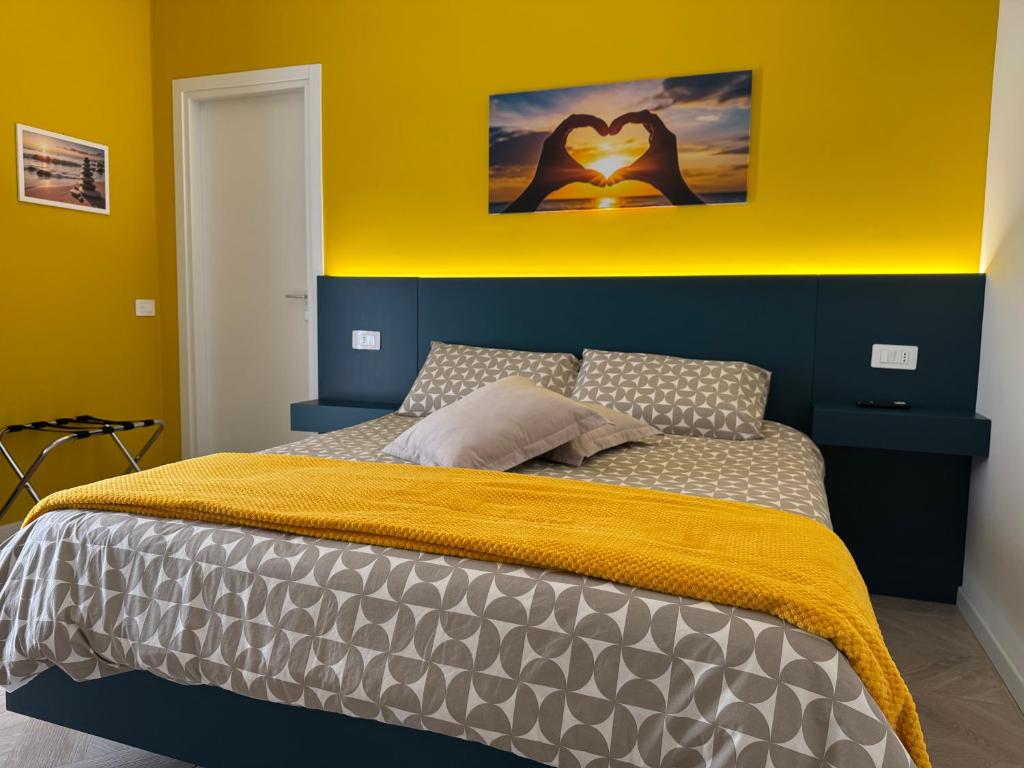 a bedroom with a bed with a yellow wall at HOUSE on sunday SOLE in Crotone