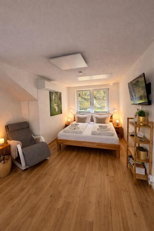 a bedroom with a bed and a chair in it at Im Wald in Gleiszellen-Gleishorbach