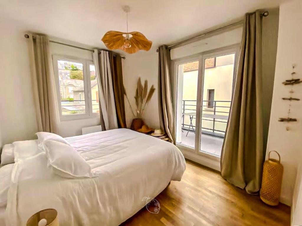 a bedroom with a white bed and a large window at Coconing Plage Pléneuf Val André in Pléneuf-Val-André