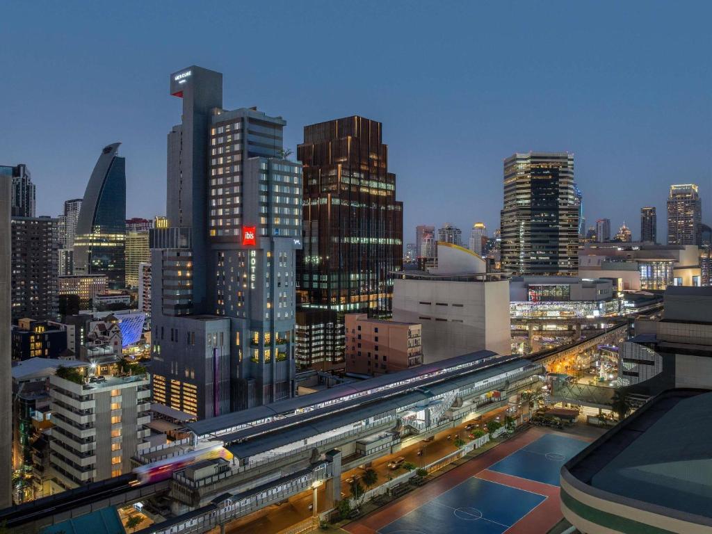 a view of a city at night with trains at ibis Bangkok Siam in Bangkok