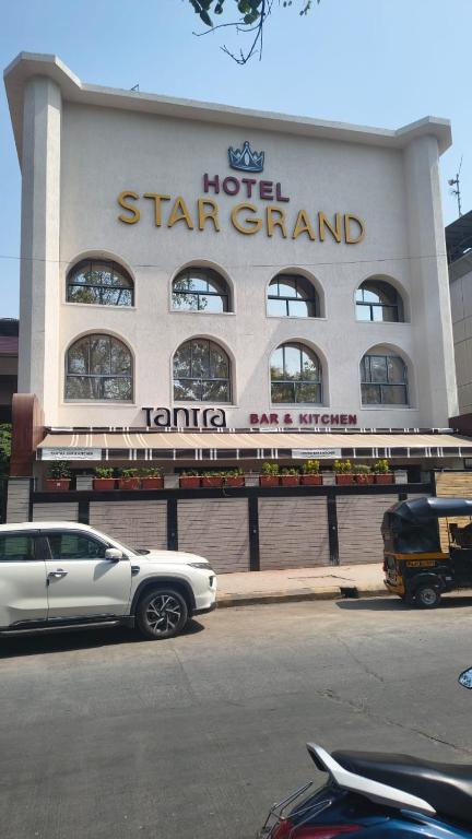 a white car parked in front of a hotel star grand at Mosaic Go Star Grand in Navi Mumbai