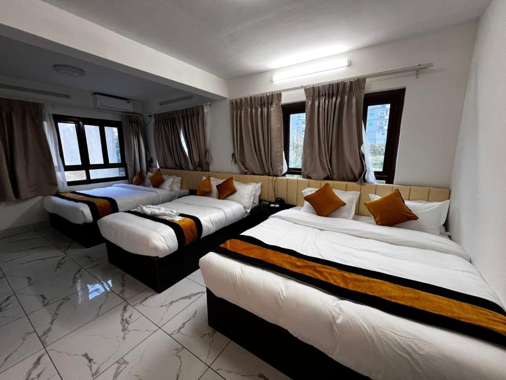 a hotel room with three beds and windows at Mandala Resorts & Events in Panepa
