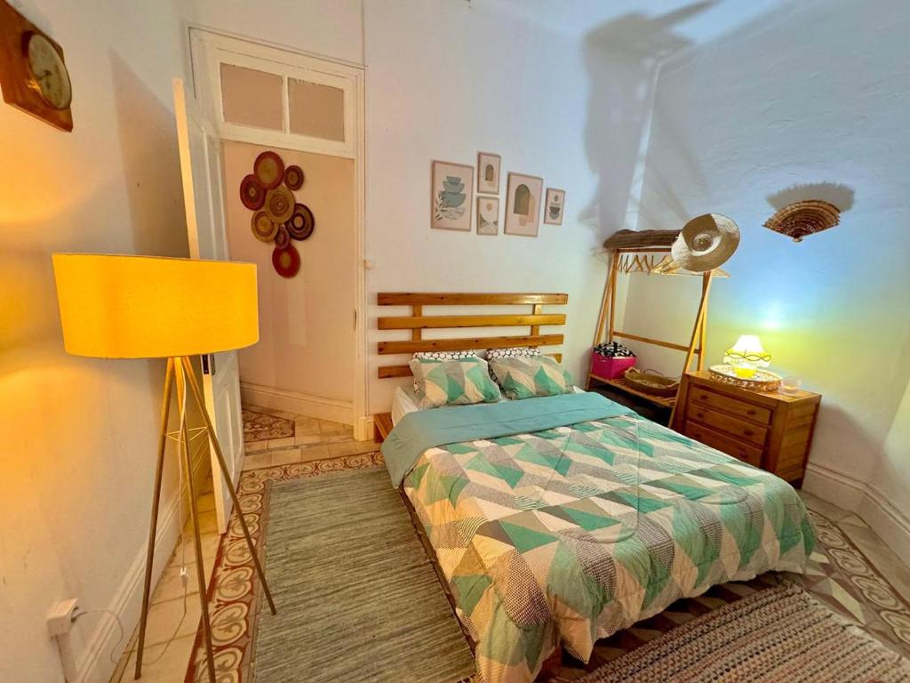 a bedroom with a bed and a yellow lamp at Appartement paisible in Tunis