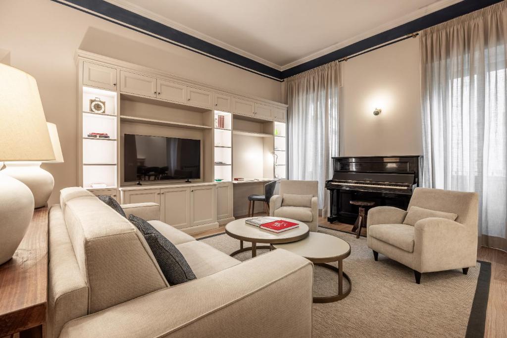 a living room with a couch and a piano at Brunelleschi Prestige by MMega in Florence