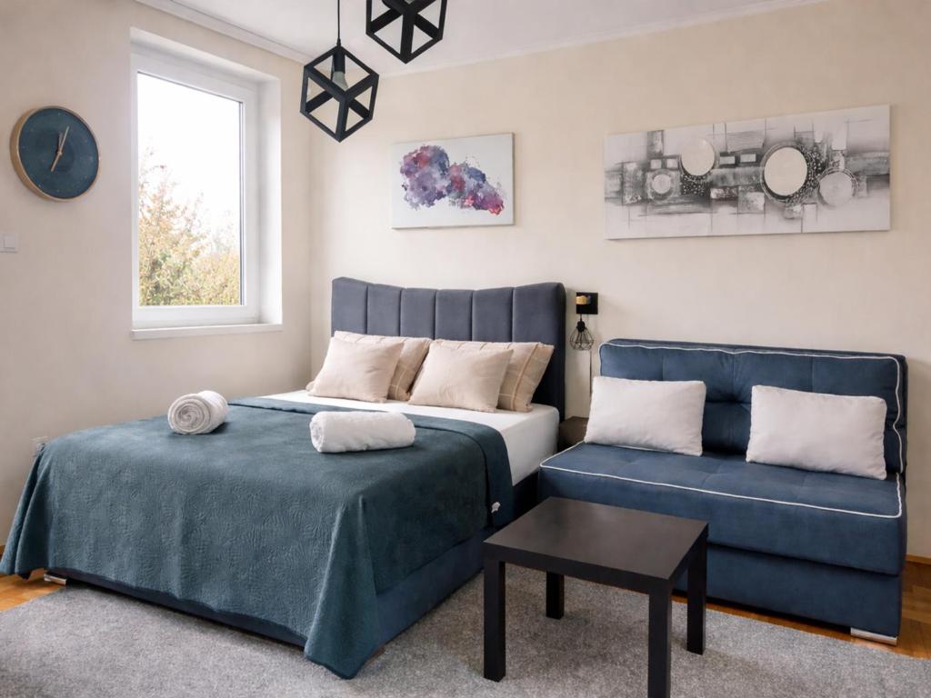 a bedroom with a bed and a blue couch at GALAKTIK centar in Apatin