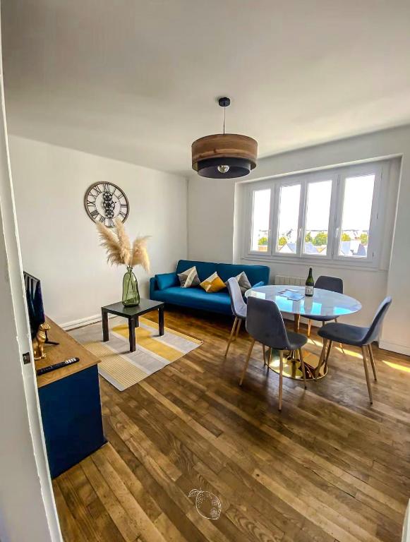 a living room with a blue couch and a table at TiArMor Saint-Brieuc Ville in Saint-Brieuc