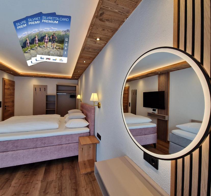 a hotel room with two beds and a mirror at Apartment Lamtana in Ischgl