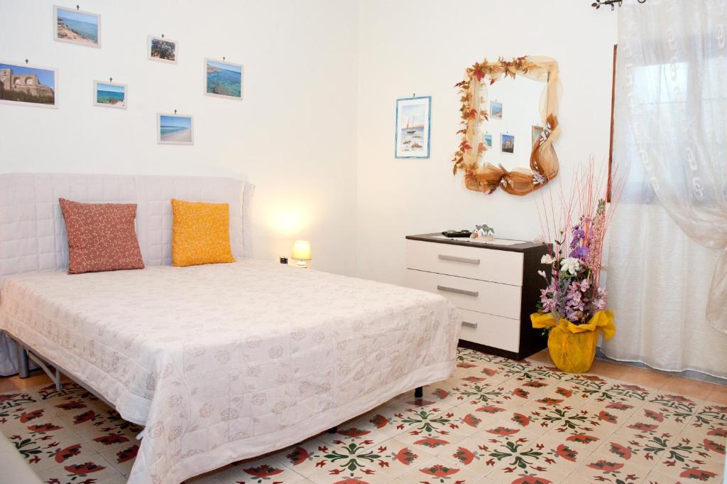a bedroom with a white bed and a dresser at La Casa di Baldo in Ugento