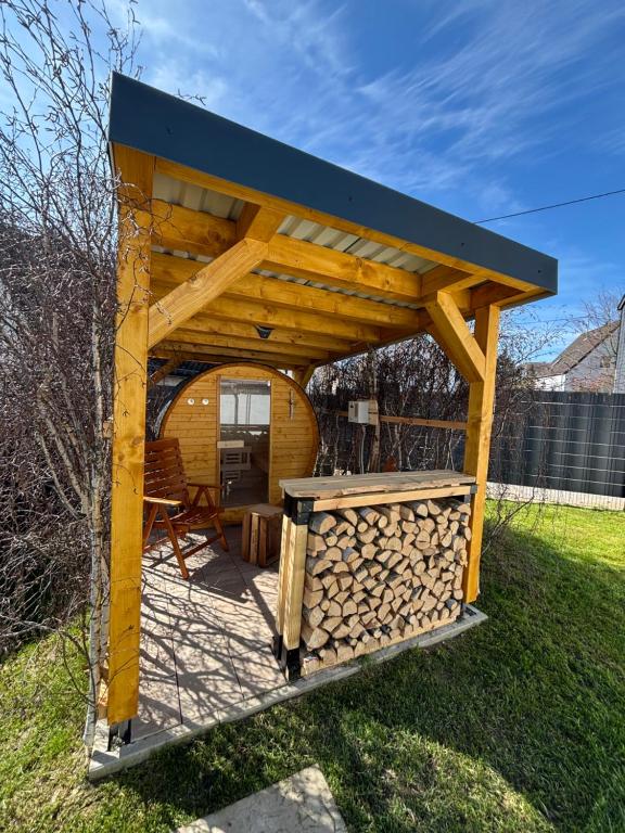 a wooden gazebo with a pile of fire wood at Tiny House mit Garten und Sauna in Karbach