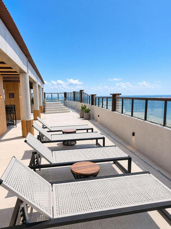 a row of tables on a balcony with the ocean at Brasil Tropical Luxury Ocean View in Fortaleza