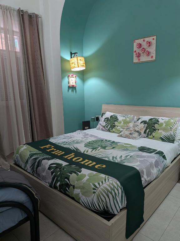 a bed in a room with a blue wall at Casetta FRM home in Naples