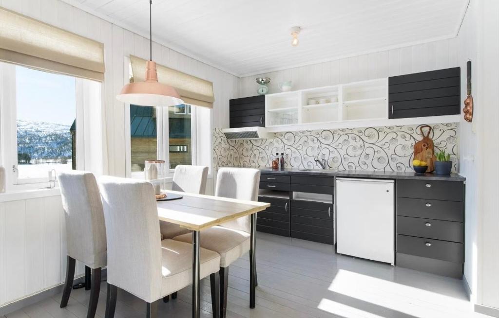 a kitchen with a dining table and white chairs at Small Cozy apartment with Wi-Fi in Tjørhom