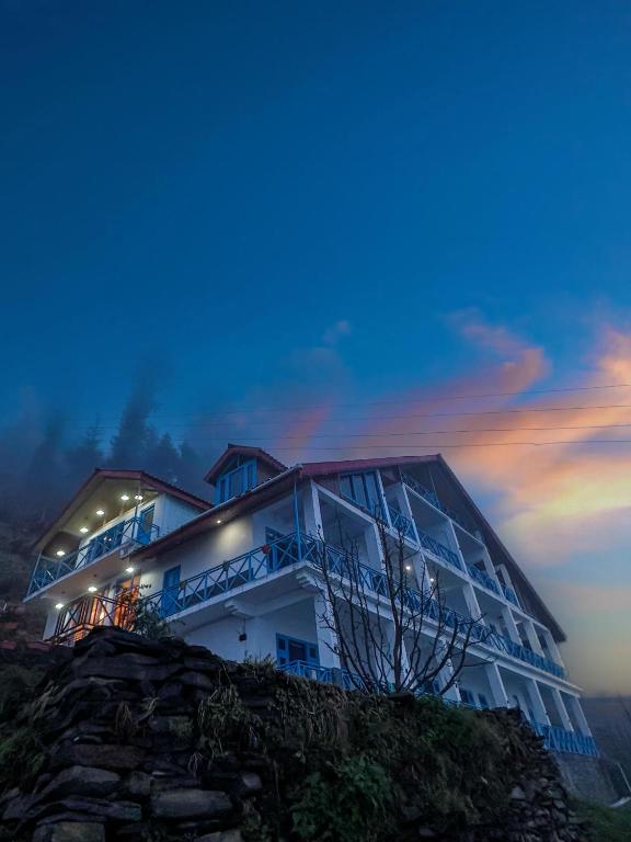 a building on top of a hill at night at The Blue Mont Sojha Jibhi in Shoja