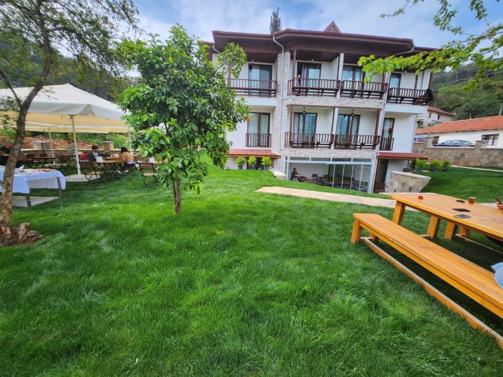 a building with a yard with benches and tables at Akcapinar Korfez Butik Otel in Akyaka