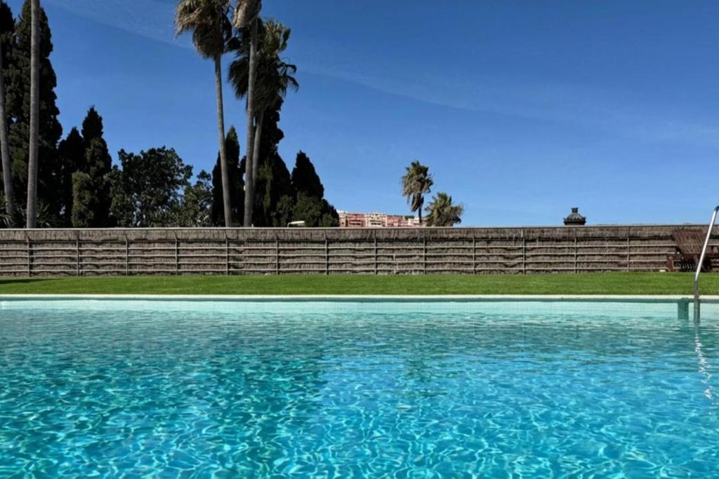 a swimming pool with blue water in front of a fence at Pool- AirCon- Quiet&Peaceful- FamilyFriendly in Manilva
