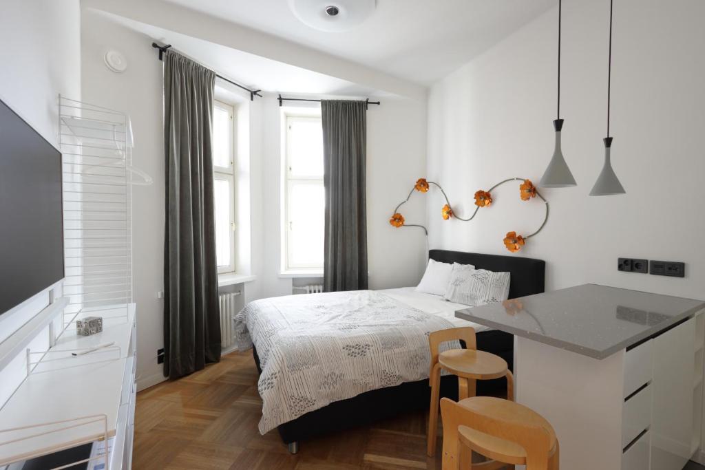 a white bedroom with a bed and a desk at Stylish studio in the centre in Helsinki
