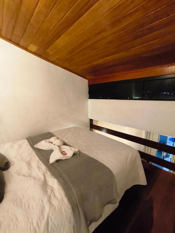 a bedroom with a bed with a towel on it at Loftshorizontedesalvina in Búzios