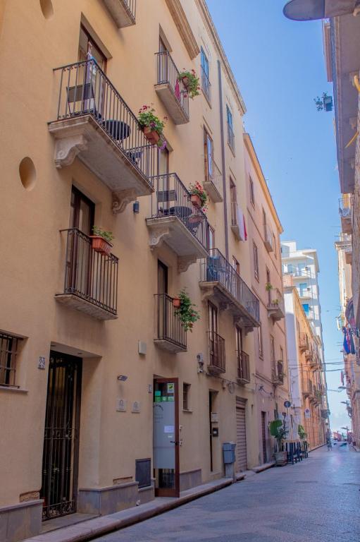 a building with balconies and potted plants on a street at Porta delle Botteghelle in Trapani