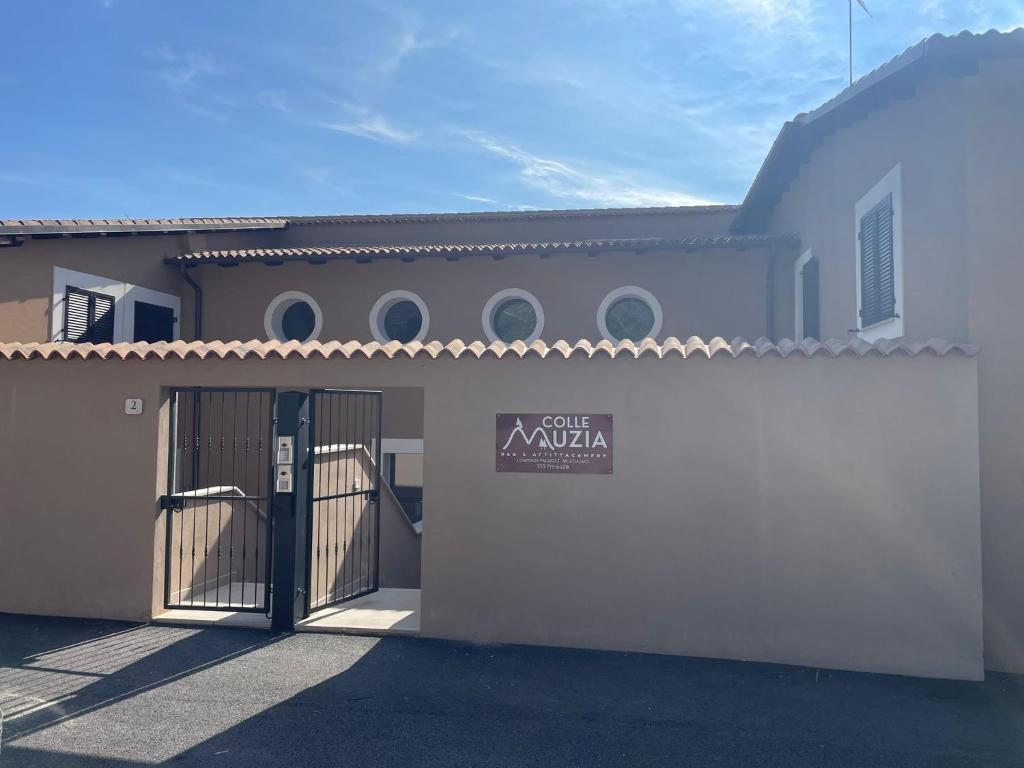 a white building with a gate with a sign on it at Colle Muzia B&B e Affittacamere in Muccia