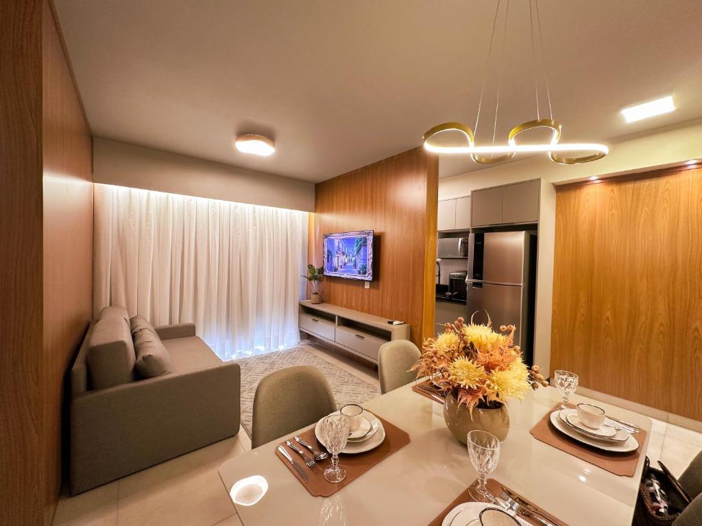 a room with a dining table and a living room at Ribeirão Premium Apogeo in Ribeirão Preto