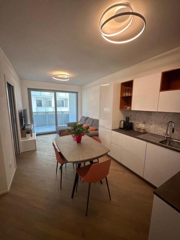 eine Küche und ein Wohnzimmer mit Tisch und Stühlen in der Unterkunft Casa Delmo Comfort, eleganza e posizione strategica nel cuore della Valtellina in Sondrio