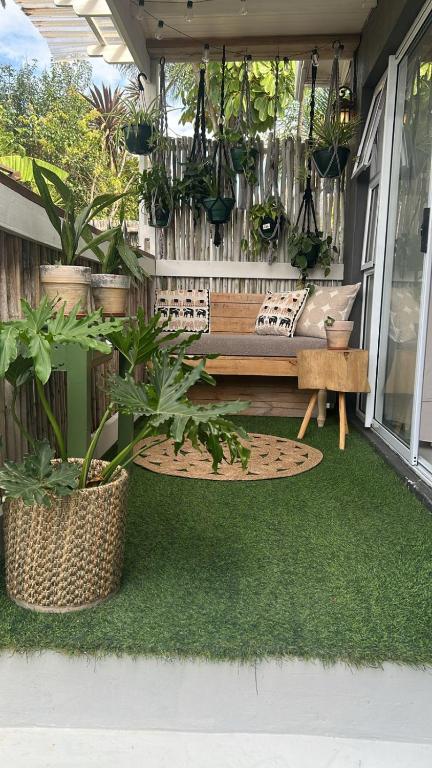 a patio with a bench and potted plants at Private big Apartment in Eversdal