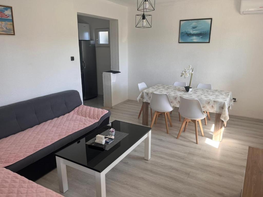 a living room with a couch and a table and chairs at Apartman M&D in Neum