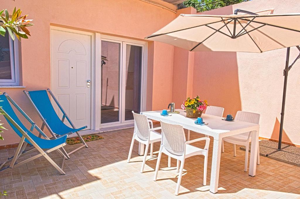 a patio with a table and chairs and an umbrella at Appartamento Celestina Mare in Portoferraio