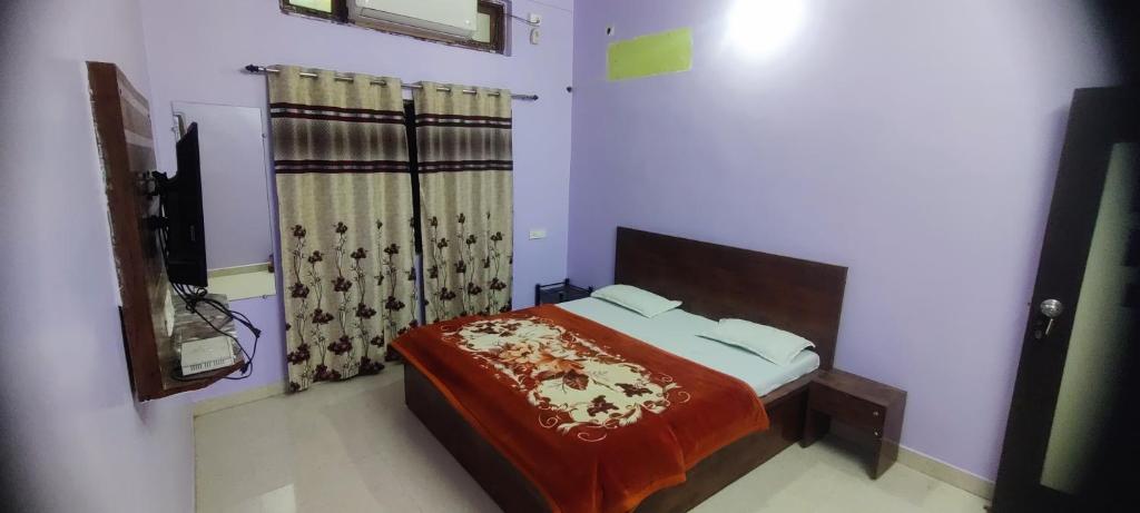 a bedroom with a bed with a red blanket on it at Hotel Shree palace in Jabalpur