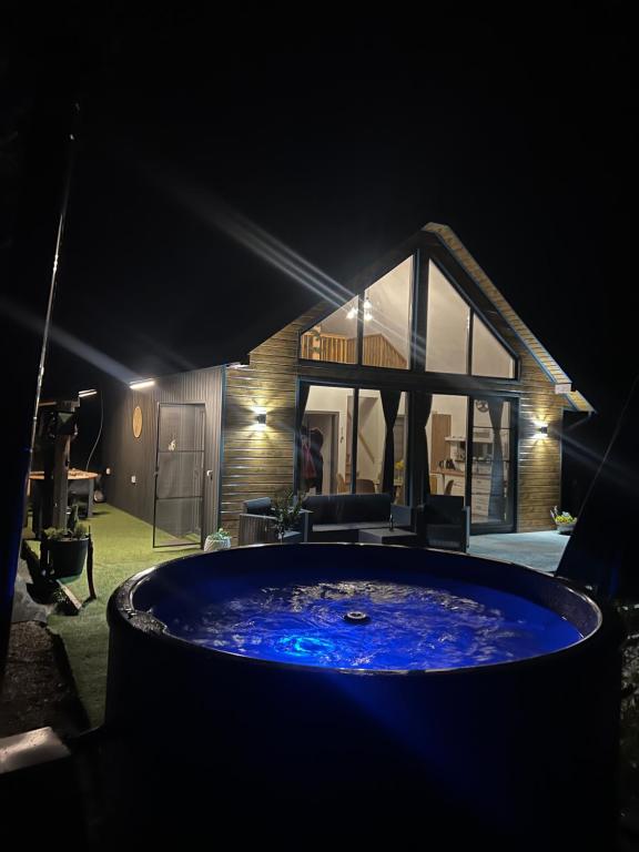 a hot tub in front of a house at night at Arbor in Vadu Crişului