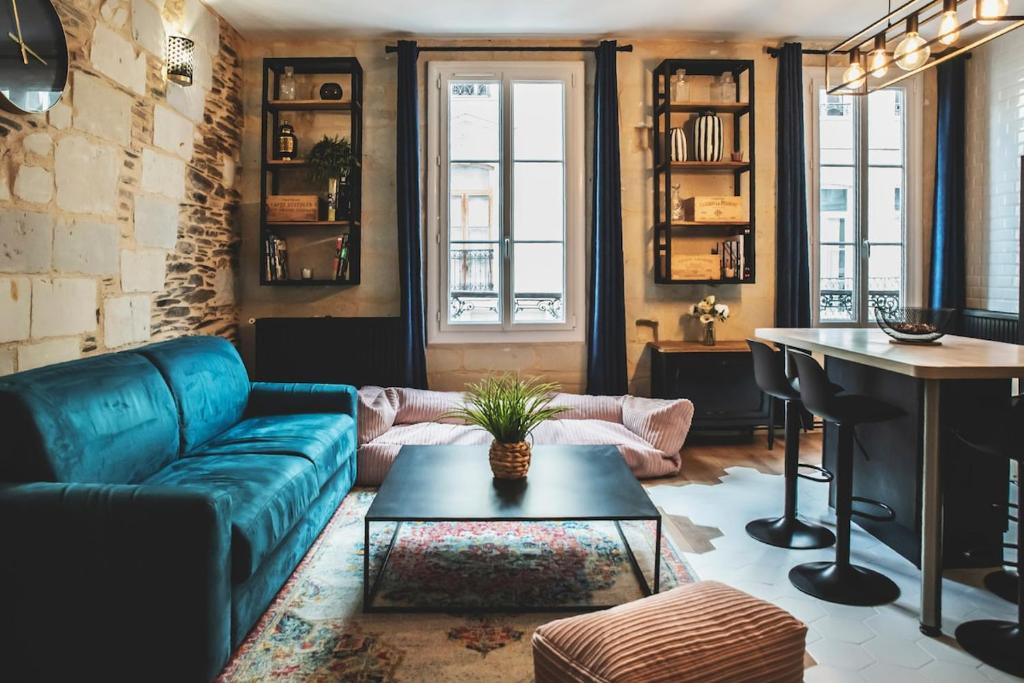 a living room with a blue couch and a table at Le charmant, Hyper Centre Angers in Angers