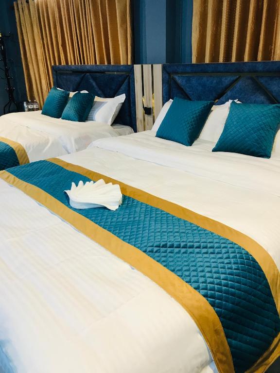 two beds in a hotel room with a towel on them at Mita Hotel - Land of Himalayas in Dhulikhel