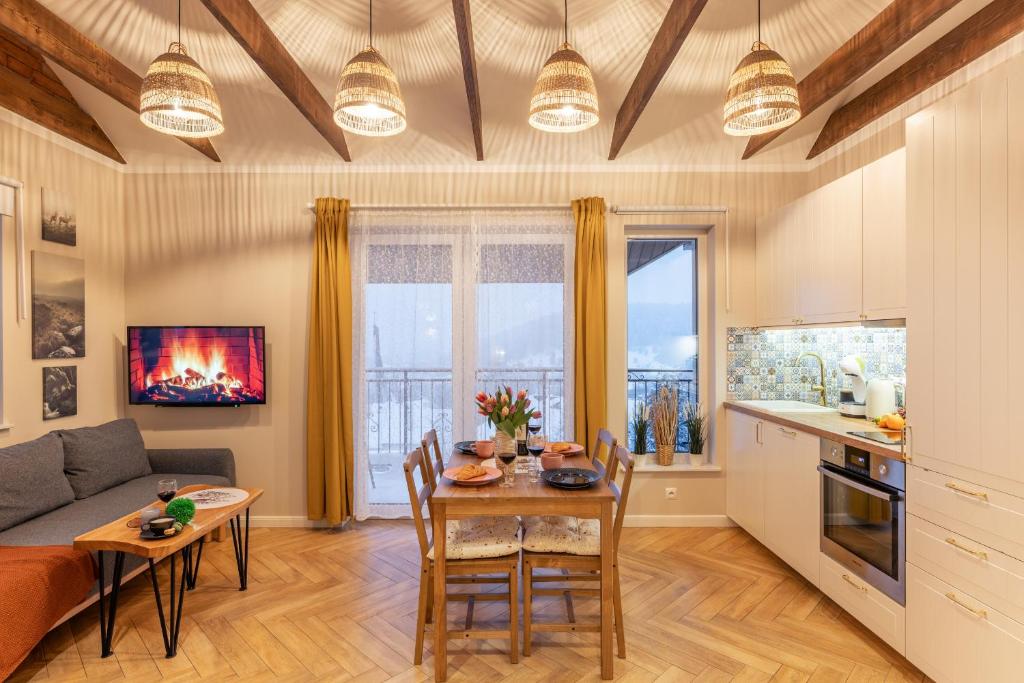 a kitchen and living room with a table and a couch at Villa Kasztelan Apartamenty in Ustrzyki Dolne