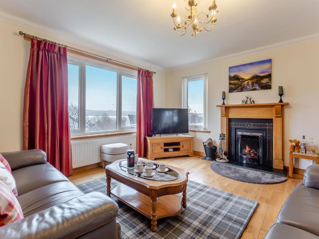 a living room with a couch and a fireplace at Bramble Cottage in Gairloch