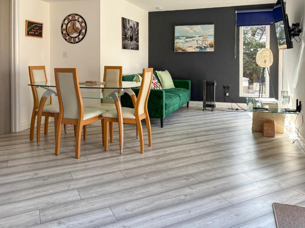 a living room with a table and chairs and a green couch at Ashtree Hideaway in Brandon