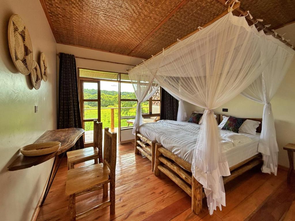 a bedroom with a bed with a canopy at Kibale Riverside Camp in Kamwenge