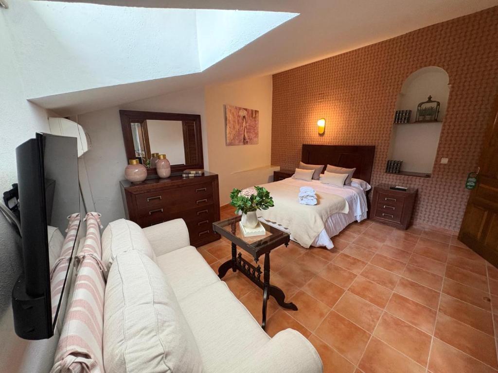 a living room with a bed and a couch at Las 6 llaves in Baeza