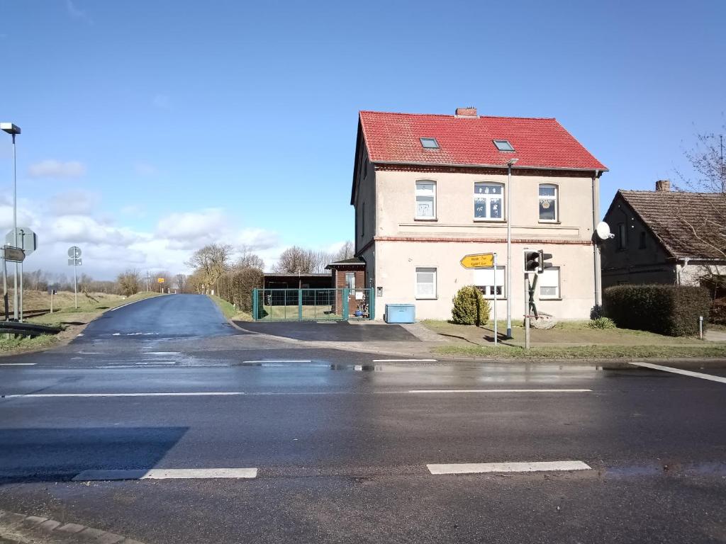 an empty street with a house and a road at Ferienwohnung Alte Post in Knorrendorf