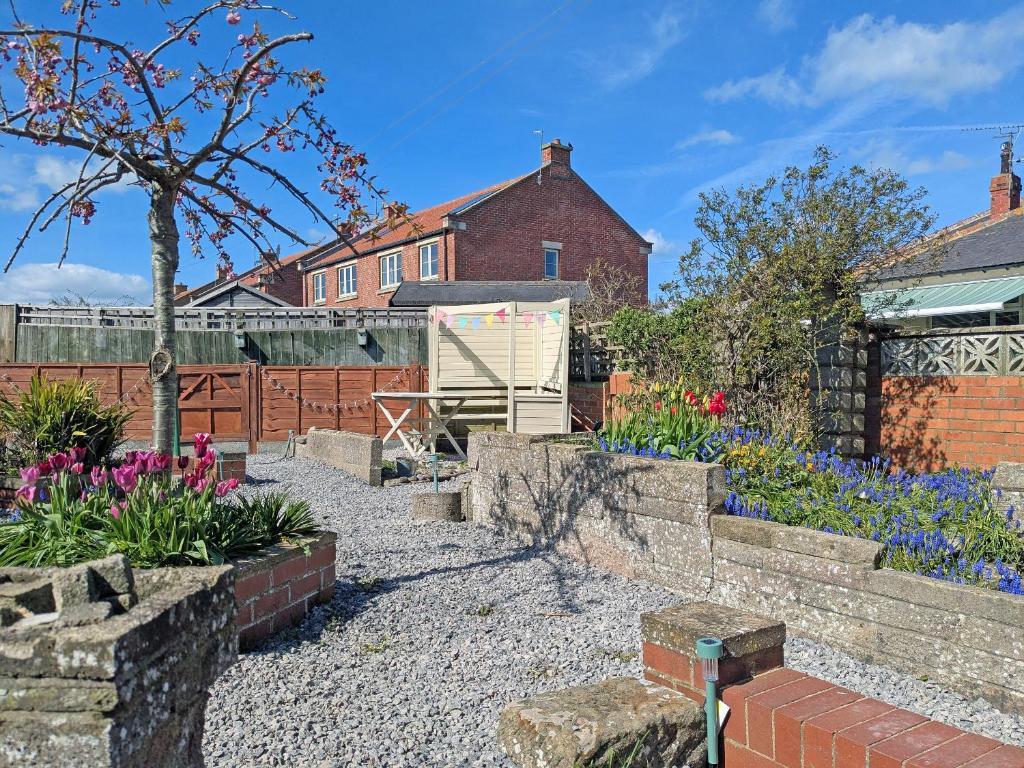 a garden with colourful flowers and a fence at Longshore in Runswick