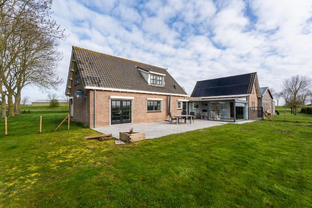 a house with a large yard with a patio at t Huysje van Klippel in Tholen