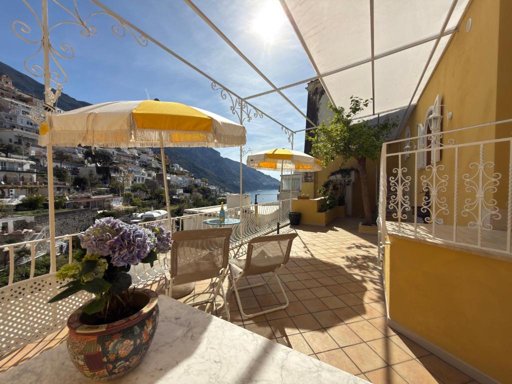 a balcony with a table with a vase of flowers at Domus Floris in Positano