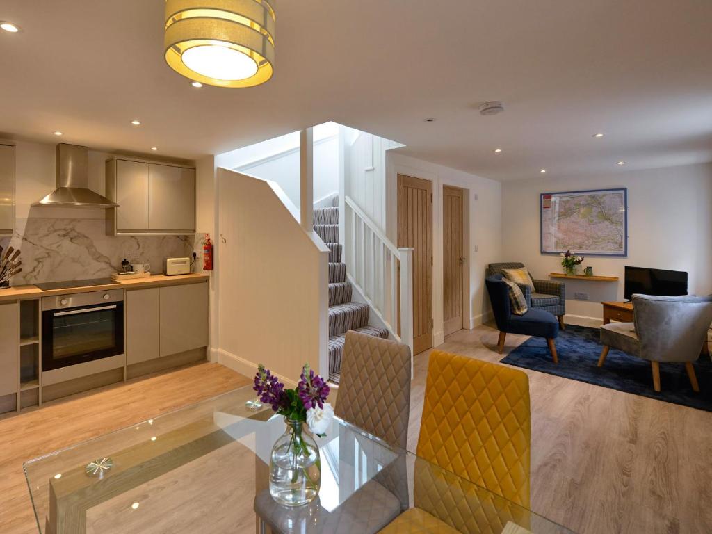 a kitchen and living room with a table and chairs at Harris Cottage - Uk40056 in Aberfeldy
